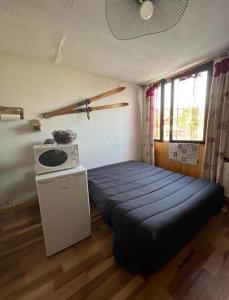 um pequeno quarto com uma cama e um fogão em APPARTEMENT PIED DES PISTES SUPER SAUZE em Enchastrayes