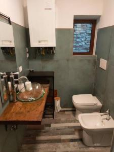 uma casa de banho com um lavatório e um WC em casa vacanze Villanova - 4 posti letto em Villanova