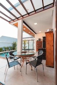 a dining room with a glass table and chairs at Hospedaria da Barra BC in Balneário Camboriú