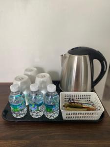 a tray with bottles of water and a tea kettle at Villa The Quarry in Segamat