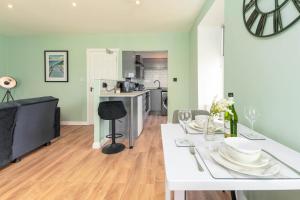 a living room with a white table and a kitchen at Clock Tower Retreat - Sea View Apartments in Morecambe in Morecambe