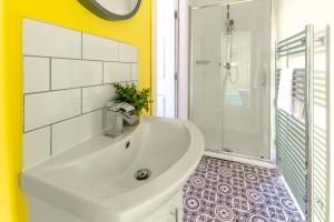 a bathroom with a white sink and a shower at Clock Tower Retreat - Sea View Apartments in Morecambe in Morecambe +30 photos