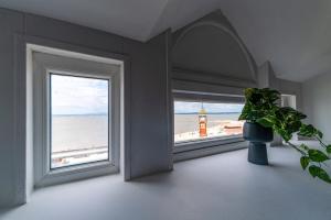 a room with a window with a view of the beach at Clock Tower Retreat - Sea View Apartments in Morecambe in Morecambe