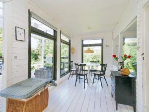 a screened in porch with a table and chairs at 4 person holiday home in Holb k in Holbæk