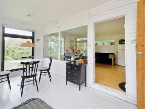 a screened in porch with a dining table and chairs at 4 person holiday home in Holb k in Holbæk