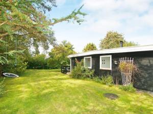 a small house with a yard next to a building at 4 person holiday home in Holb k in Holbæk