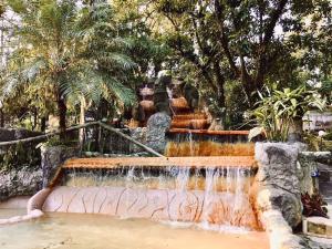 a fountain in a park with a waterfall at Hotel Kokoro Mineral Hot Springs in Fortuna