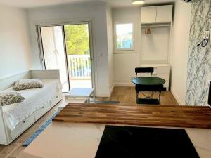 Schlafzimmer mit einem Bett, einem Tisch und einem Fenster in der Unterkunft Appartement Vue Mer - Parking - Piscine - Plage in Fréjus