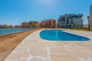 a swimming pool in a resort next to a body of water at Apartment in Gouna Tawila The Butterfly in Hurghada