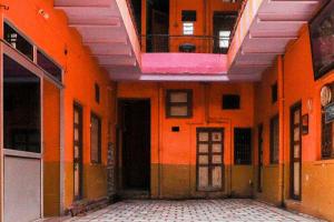 un corridoio vuoto di un edificio con pareti arancioni di Goroomgo Laxmi Bhawan Dharamshala Mathura Near Yamuna River and Dwarikadhish Temple a Mathura