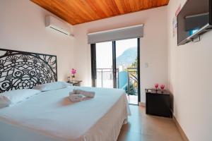 a bedroom with a large bed and a large window at Hospedaria da Barra BC in Balneário Camboriú +45 photos