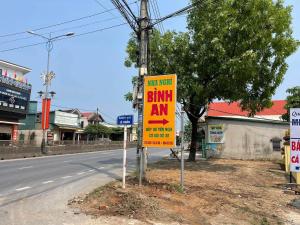 ein gelbes Schild an der Straßenseite in der Unterkunft Nhà nghỉ Bình An - Binh An Motel in Quang Tri
