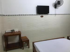 Zimmer mit 2 Betten und einem TV an der Wand in der Unterkunft Nhà nghỉ Bình An - Binh An Motel in Quang Tri