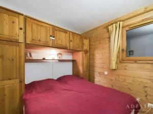 ラ・ロジエールにあるAppartement Montvalezan-La Rosière, 3 pièces, 6 personnes - FR-1-398-499の木造キャビンの赤いベッド1台が備わるベッドルーム1室です。