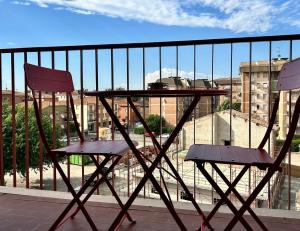 un tavolo e 2 sedie seduti su un balcone di CASA MATISSE a Parma