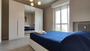 una camera con letto blu e specchio di CASA MATISSE a Parma