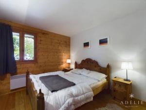 a bedroom with a bed and a wooden wall at Appartement Montvalezan-La Rosière, 4 pièces, 8 personnes - FR-1-398-534 in La Rosière