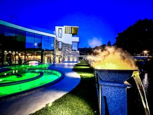 un edificio con una fontana di fronte ad esso di notte di Grande Hotel Thermas Nature & SPA a Termas de São Pedro do Sul