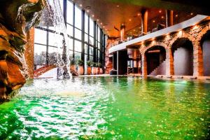 a swimming pool with a fountain in a building at Grande Hotel Thermas Nature & SPA in Termas de Sao Pedro do Sul