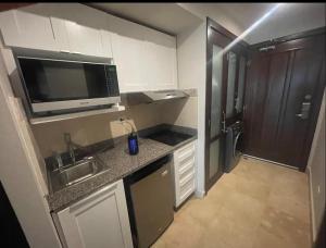 a small kitchen with a sink and a microwave at En la playa con piscina in Punta Cana