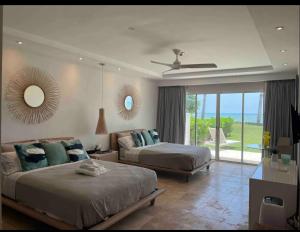 een grote slaapkamer met 2 bedden en een spiegel bij En la playa con piscina in Punta Cana