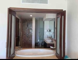 a bathroom with a large tub and a sink at En la playa con piscina in Punta Cana