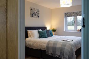 una camera da letto con un letto grande con cuscini blu di Family Country Cottage with Stunning Mountain View sleeps 12 a Myddfai