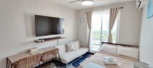 a living room with a couch and a flat screen tv at Z's Place in Suba