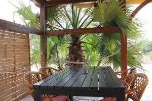 a black table and chairs on a porch with a palm tree at Apartments Lukas in Medulin
