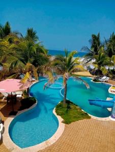 una gran piscina con palmeras y el océano en Hotel Hawaian Paradise, en El Hawaii