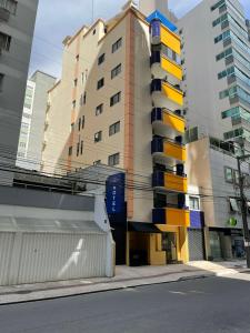 um edifício com varandas coloridas numa rua da cidade em Hotel Di Sica em Balneário Camboriú