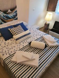 Cama con sábanas y almohadas azules y blancas en Casa DiLù en Sannicola