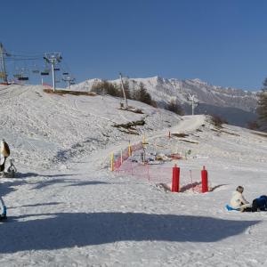 um grupo de pessoas sentadas na neve numa pista de esqui em APPARTEMENT PIED DES PISTES SUPER SAUZE em Enchastrayes