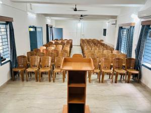 a lecture hall with chairs and tables and a podium at Levi Home Guest House & Retreat Centre in Siliguri