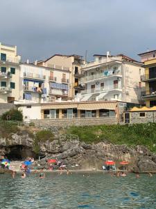een groep mensen op een strand in het water bij La Spiaggetta Apartament in Marina di Camerota