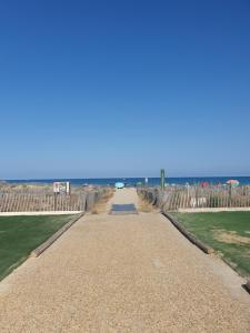 une route menant à la plage avec l'océan en arrière-plan dans l'établissement T2 rez de jardin direct plage, au Barcarès