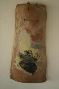 a painting of a boat in the water on a wall at Nelly's Coastal Family House in Hydra