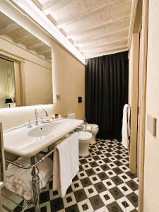 uma casa de banho com um lavatório e um WC em Casa del Fauno em Montepulciano