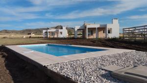 a swimming pool in front of a house at Valle Ventana in San Andres de las Sierras