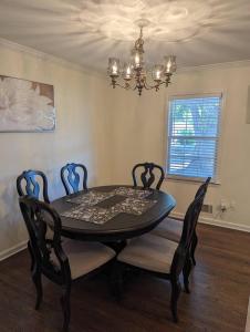 a dining room table with four chairs and a chandelier at Home away from home in Marietta