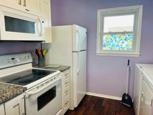 a kitchen with a white refrigerator and a window at That's What Sea Said home in Holden Beach