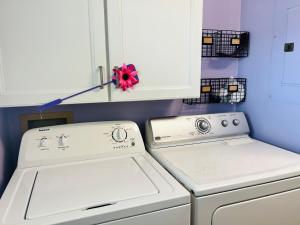 a kitchen with white appliances and a white cabinet at That's What Sea Said home in Holden Beach