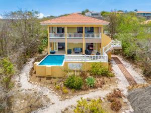 an aerial view of a yellow house with a swimming pool at Holiday Home Gran Veranda with private pool, Coral Estate in Willemstad