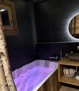 a bath tub with purple lighting in a bathroom at Appartement style chalet 5* vue Mont-Blanc - Arc 1950 in Arc 1950