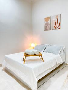 een witte slaapkamer met een bed met een tafel erop bij Homestay Ar-Rayyan 2 Kota Bharu in Kota Bharu