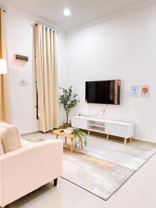 un soggiorno con un divano bianco e una TV di Homestay Ar-Rayyan 2 Kota Bharu a Kota Bharu Altre 7 foto