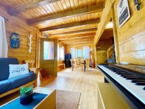 una sala de estar con un piano en una cabaña de madera en Baita Nord, en Linguaglossa