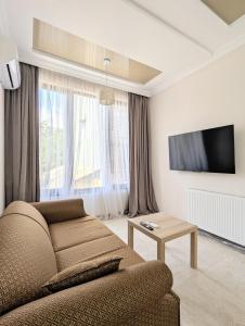 a living room with a couch and a tv at Cosy At Home in K'obulet'i