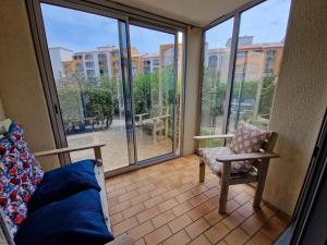 Cette chambre dispose d'un balcon avec vue sur un bâtiment. dans l'établissement T2 rez de jardin direct plage, au Barcarès