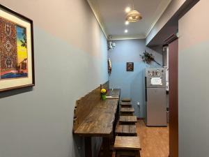 a room with a wooden table and a refrigerator at Avenue Hostel Yerevan in Yerevan